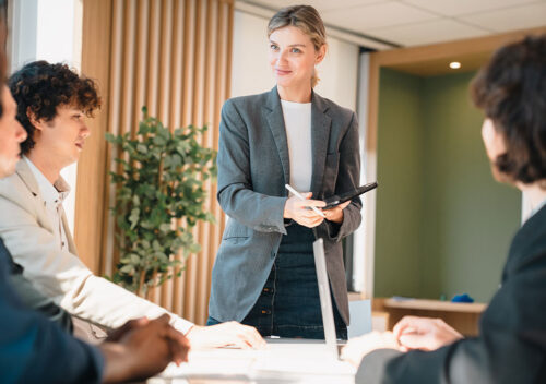 Woman standing up in the workplace giving a presentation to a group