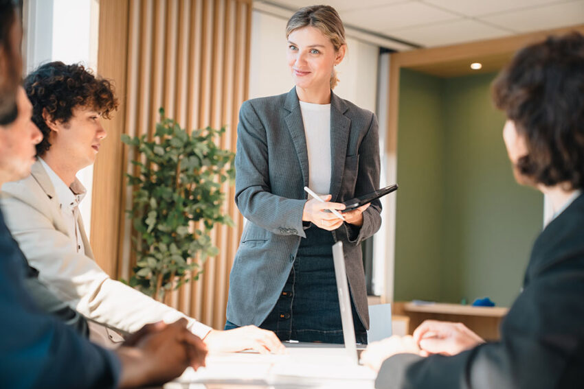 Woman standing up in the workplace giving a presentation to a group